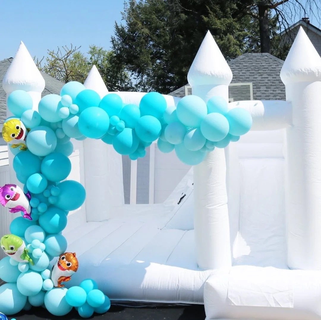 Château gonflable blanc décoré de ballons bleus sur le thème de la mer : une touche d'élégance et de divertissement pour vos événements spéciaux ! Réservez dès maintenant pour des souvenirs inoubliables.