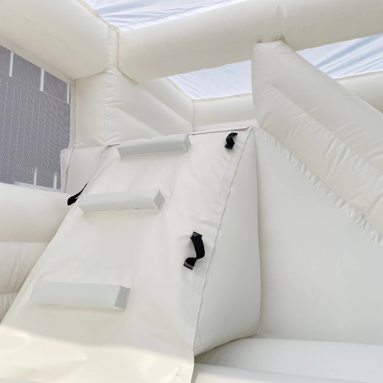 Vue de l'intérieur du château gonflable blanc, montrant les escaliers menant au toboggan hyper glissant. Réservez dès maintenant pour des moments de plaisir inoubliables !