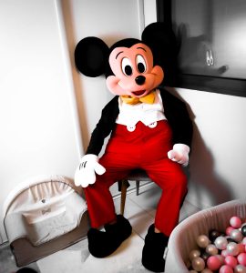 Location mascotte Mickey Mouse surprenant une petite fille de 3 ans lors d'une fête.