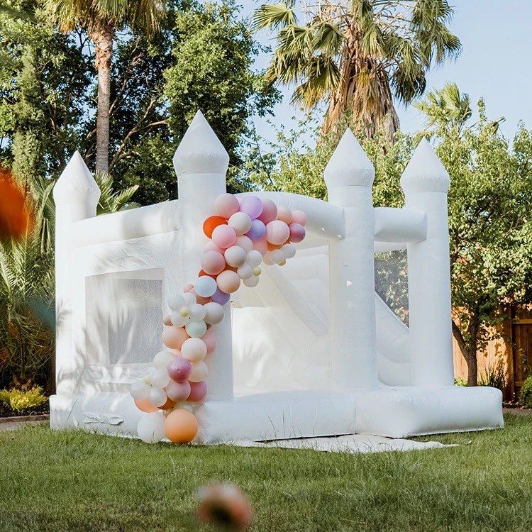 château gonflable blanc décoré avec des ballons bleus