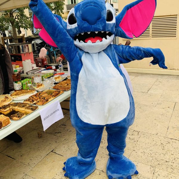 Stitch dansant joyeusement, entouré de fans émerveillés avec des étoiles dans les yeux, illustrant l'excitation et la magie de l'instant